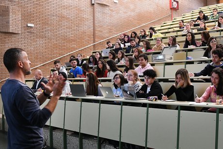 The photograph shows a lecture hall at Lugo campus.