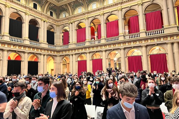 The picture shows a crowd of students applauding at the European Student Assembly.