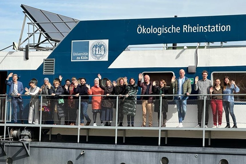 A group of people standing on the Ecological Rhein Station of the University of Cologne.