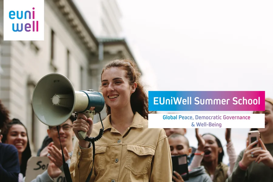 The image shows a group of enthusiastic people gathered around a young woman holding a megaphone. They appear to be at an outdoor event or rally. Prominently displayed is the EUniWell logo, along with text that reads “EUniWell Summer School - Global Peace, Democratic Governance & Well-Being”. The mood is positive and the setting suggests an emphasis on education and community involvement.