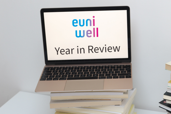 A picture of an open laptop with the EUniWell logo and the text "Year in Review" on it.