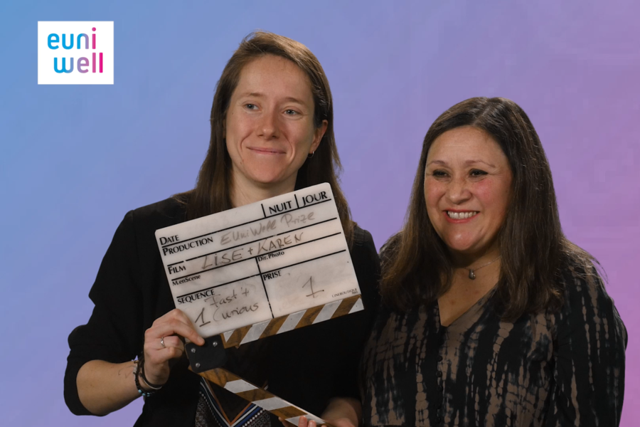 Two EUniWell Thesis prizes winners smiling and holding a clapper board