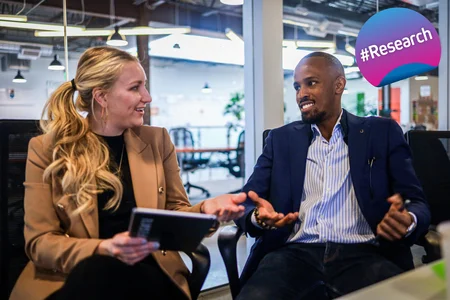 Two persons discussing and smiling in a professional setting