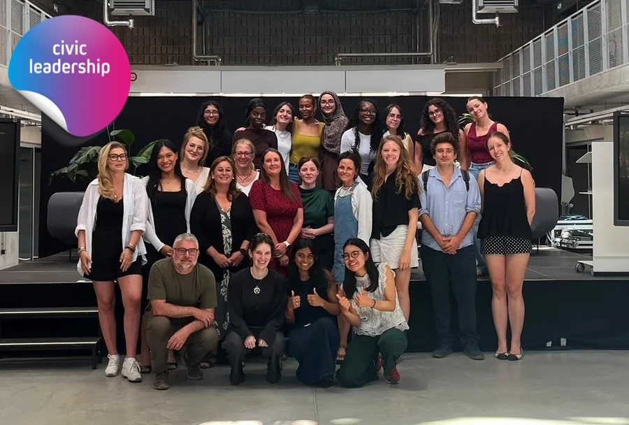 Group photo of participants, posing together in an indoor event space.