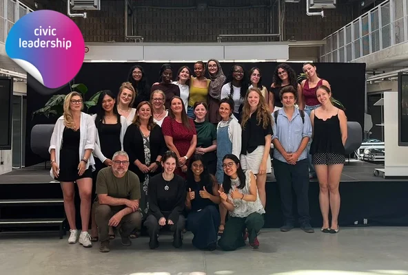 Group photo of participants, posing together in an indoor event space.