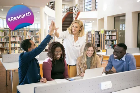 Collaborative work scene in a library, featuring a badge in the top left corner with the EUniWell color gradient (cyan to magenta) labeled 'Research'.